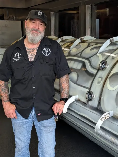 Trey Sanchez and his custom smoker at Vaqueros Texas BBQ